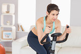Fit brunette working out on exercise bike