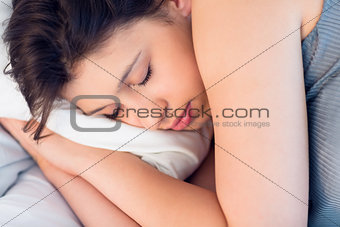 Beautiful brunette lying on bed sleeping