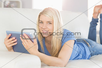 Relaxed beautiful woman using digital tablet in living room