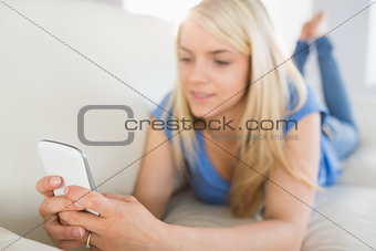 Relaxed woman text messaging in living room