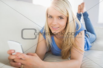 Relaxed beautiful woman text messaging in living room