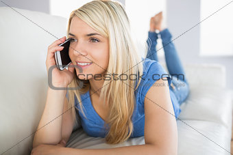 Relaxed beautiful woman using mobile phone in living room