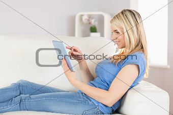 Relaxed woman using digital tablet in living room