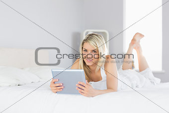 Relaxed beautiful woman using digital tablet in bed
