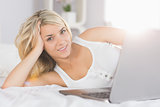 Relaxed beautiful woman using laptop in bed
