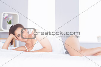 Smiling relaxed young woman lying in bed