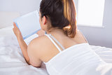 Relaxed woman using digital tablet in bed