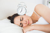 Beautiful woman sleeping in bed with alarm clock