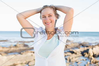 Casual woman smiling at camera by the sea