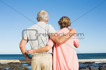 Happy casual couple looking out to sea