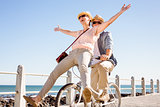 Happy casual couple going for a bike ride on the pier