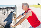 Fit mature man warming up on the pier
