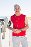 Fit mature man smiling at camera on the pier