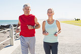 Fit mature couple jogging on the pier