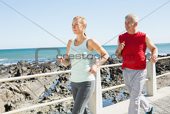 Fit mature couple jogging on the pier