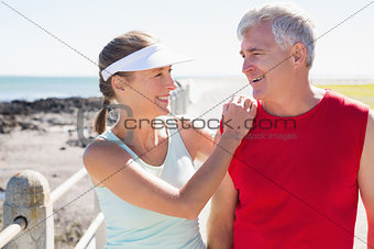 Fit mature couple warming up together on the pier