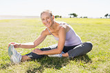 Fit mature woman warming up on the grass