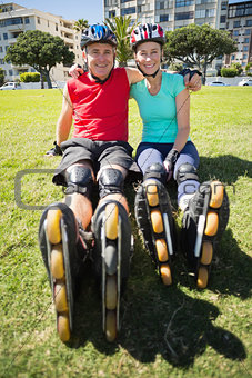 Fit mature couple wearing roller blades on the grass