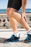 Fit man gripping his injured calf muscle