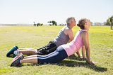 Fit mature couple warming up on the grass