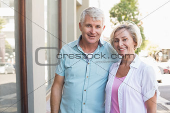 Happy mature couple smiling at camera in the city