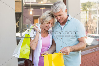 Happy mature couple looking at their shopping purchases