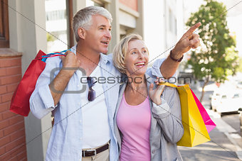 Happy mature couple walking with their shopping purchases