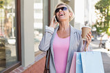 Happy mature woman walking with her shopping purchases