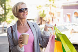 Happy mature woman walking with her shopping purchases