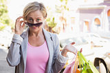 Happy mature woman smiling at camera with her shopping purchases