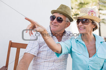 Happy mature couple sitting on bench in the city