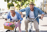 Happy mature couple going for a bike ride in the city