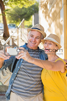 Happy mature couple taking a selfie together in the city