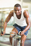 Portrait of man working out on exercise bike at gym