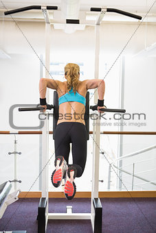Rear view of fit woman doing crossfit fitness workout gym
