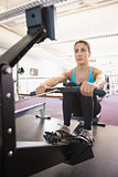 Young woman working on fitness machine at gym