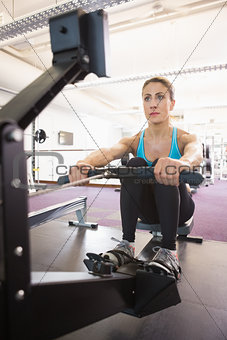 Young woman working on fitness machine at gym