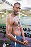 Shirtless young muscular man posing in gym