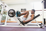 Male weightlifter doing leg presses in gym