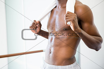 Mid section of shirtless muscular man in gym