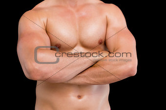 Mid section of shirtless muscular man with arms crossed