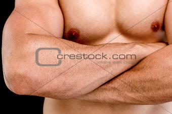 Mid section of a shirtless muscular man with arms crossed