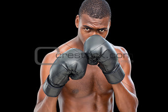 Shirtless muscular boxer in defensive stance