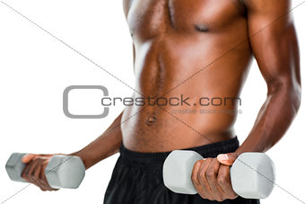 Mid section of fit shirtless man lifting dumbbells