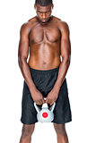 Shirtless fit young man lifting kettle bell
