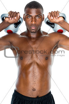 Shirtless fit young man lifting kettle bells