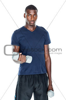 Portrait of a casual man lifting dumbbells