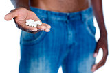 Mid section of man holding vitamin pills in hand
