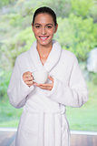 Beautiful woman in bathrobe having tea outdoors