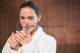 Beautiful woman in bathrobe having tea